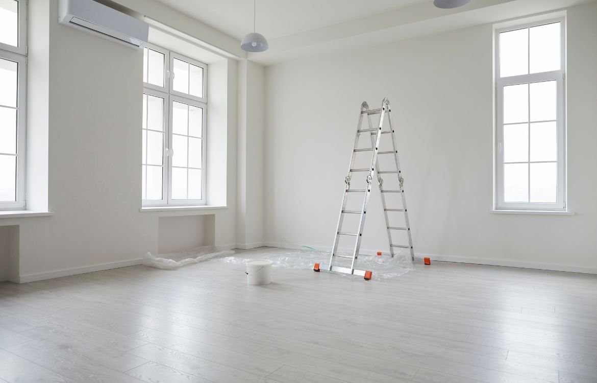 Painting tools and a ladder in a empty room